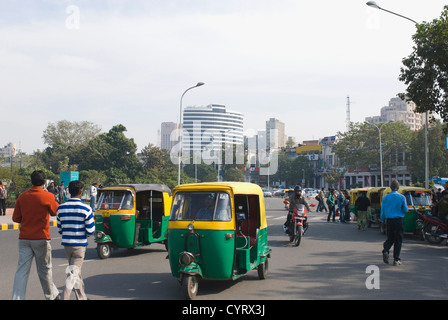 Risciò motorizzati e persone che si muovono su strada di New Delhi, India Foto Stock