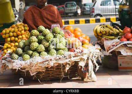 Fornitore femmina frutti di vendita in un mercato in stallo, New Delhi, India Foto Stock