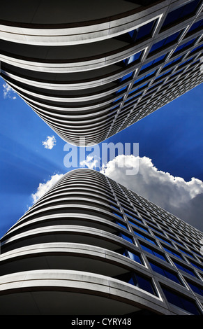 Un simmetrico Composito Digitale dei due grattacieli. Cerca fino a un profondo blu del cielo di mezzogiorno con nuvole e Sunburst Foto Stock