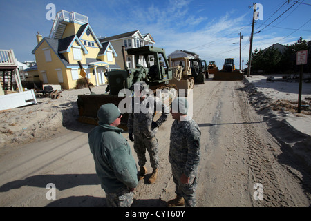 Soldati dal centocinquantesimo e centosessantesimo ingegnere società, New Jersey Esercito Nazionale Guardia, discutere le opzioni di spostamento per i loro D7 Bulldozer prima di eseguire il rifornimento di spiaggia operazioni nov. 8, 2012, nella devastata Holgate sezione di Long Beach Island, Foto Stock