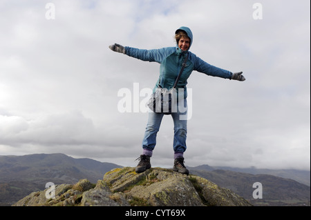 Viste intorno Loughrigg cadde vicino a Ambleside Lake District donna in scarponi la scalata verso la cima sui giorni di autunno Foto Stock