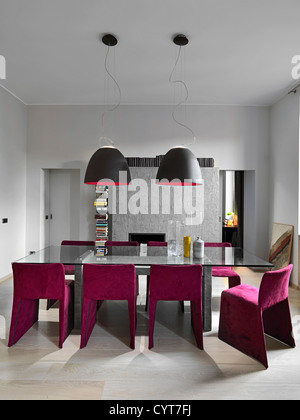 Moderno tavolo da pranzo in vetro con pavimento in legno e tessuto viola sedie Foto Stock
