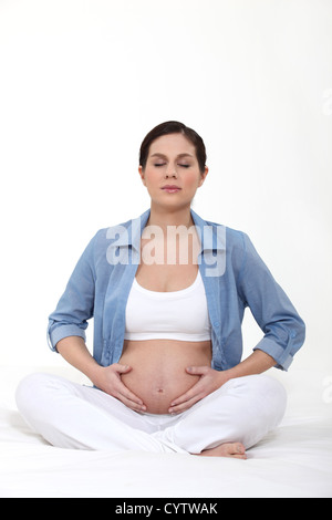 Donna incinta a praticare yoga Foto Stock