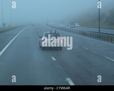 Un assemblaggio di veicoli di trasporto nella nebbia il traffico su un Regno Unito autostrada nel nord Inghilterra. Foto Stock