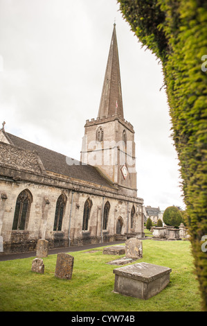 PAINSWICK, Regno Unito — Cemetary and Steeple at the Parish Church of St Mary in Painswick, Gloucestershire, nella regione inglese delle Cotswolds. A destra si trova parte dei famosi Yew Trees della chiesa. Foto Stock