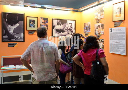 CITTÀ DI HO CHI MINH, Vietnam: I visitatori del museo esaminano le fotografie che documentano gli effetti dell'Agente Orange al Museo dei resti della guerra. La mostra presenta la documentazione storica dell'uso di defolianti chimici durante la guerra del Vietnam. Il museo conserva queste fotografie come parte della sua collezione permanente che mostra gli impatti a lungo termine della guerra. Foto Stock