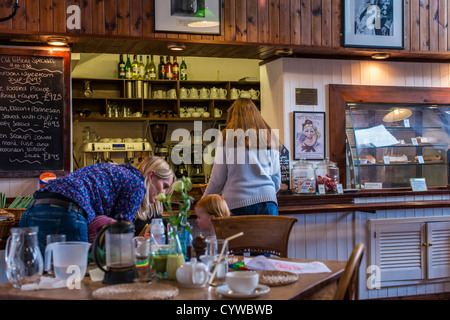 Bovey Tracey, Devon, Inghilterra. 8 novembre 2012. Un cafe scene con una donna e suo figlio e una donna al contatore essendo servita Foto Stock