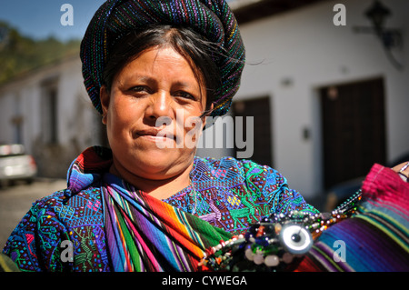 ANTIGUA GUATEMALA, Guatemala - Una donna mostra i suoi tessuti in vendita per le strade del centro di Antigua Guatemala. Il Guatemala ha una tradizione molto forte di tessitura. Famosa per la sua architettura barocca spagnola ben conservata e per le numerose rovine dei terremoti, Antigua Guatemala è un sito patrimonio dell'umanità dell'UNESCO ed ex capitale del Guatemala. Foto Stock