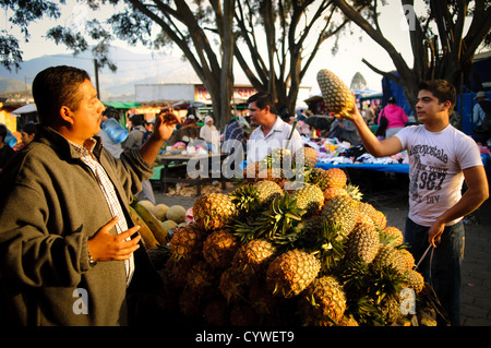 ANTIGUA GUATEMALA, Guatemala — Un cliente acquista un ananas presso il mercato principale di Antigua, Guatemala. Foto Stock