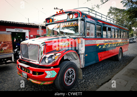 Un dipinto luminosamente chicken bus sulla strada di Antigua, Guatemala. Foto Stock