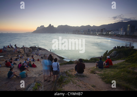 Persone su Ponta do Arpoador guardando il tramonto, Ipanema, Rio de Janeiro, Brasile Foto Stock