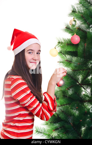 Ragazza giovane indossando beanie decorare albero di natale, contatto visivo, colpo verticale Foto Stock