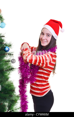 Ritratto di giovane ragazza che indossa beanie, in piedi vicino ad albero di natale, contatto visivo, colpo verticale Foto Stock