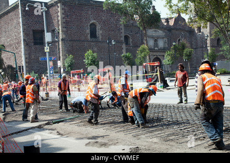 Lavoratori edili posa di griglia metallica fondamenti su strada, José María Pino Suárez, in Città del Messico DF Foto Stock