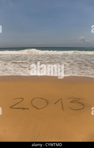 2013 scritto nella sabbia sulla spiaggia con le onde del mare Foto Stock