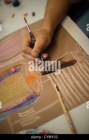 Una ragazza di disegno con gesso e pastelli in un'arte lezione di classe in un secondario completo scuola in Galles REGNO UNITO Foto Stock