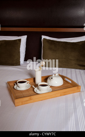 Vassoio con caffè su un letto in una stanza di un hotel Foto Stock