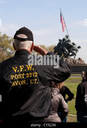 10 novembre 2012: durante il giorno dei veterani di celebrazioni, un US Marine Corps veterano saluta la bandiera di fronte all'Iwo Jima Memoriale di guerra, Washington DC, Stati Uniti d'America Foto Stock