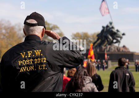 10 novembre 2012: durante il giorno dei veterani di celebrazioni, un US Marine Corps veterano saluta la bandiera di fronte all'Iwo Jima Memoriale di guerra, Washington DC, Stati Uniti d'America Foto Stock