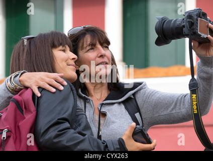 Due giovani donne che prendono un autoritratto con una Nikon fotocamera reflex digitale Foto Stock