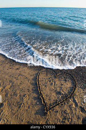 Un cuore disegnato nella sabbia sulla spiaggia Foto Stock