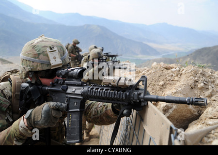 Un Army US National Guardsman scansiona la vicina linea di cresta lungo con altri membri del Team di Ricostruzione Provinciale Kunar Aprile 19, 2012 in provincia di Kunar, in Afghanistan a seguito di un impegno con le forze dei talebani. Il gruppo ha preso le piccole armi da fuoco da una montagna vicina alto durante una routine di pattugliamento e fu in grado di sopprimere il nemico con l'assistenza delle locali forze di sicurezza nazionali afgane. Foto Stock