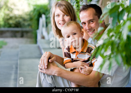 Felice perfetta giovane famiglia con il papà, mamma e figlio all'aperto avente fun Foto Stock