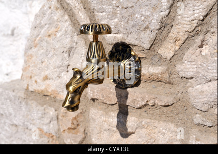 Esterno decorativo rubinetto di acqua sul muro di pietra Foto Stock