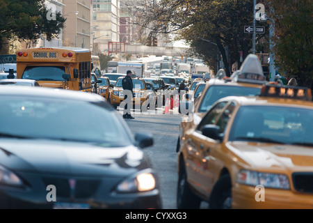 Linea di persone fino ad acquistare benzina a un Hess stazione di gas nel quartiere di Clinton di Manhattan a New York Foto Stock