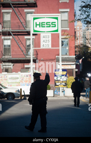 Linea di persone fino ad acquistare benzina a un Hess stazione di gas nel quartiere di Clinton di Manhattan a New York Foto Stock