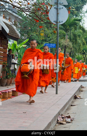 I monaci buddisti a raccogliere i loro cibo quotidiano Alms a Sunrise a Luang Prabang, Laos Foto Stock