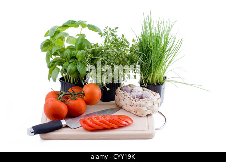 Erbe con tagliere di pomodoro e aglio Foto Stock