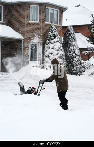 L'uomo la rimozione di neve dal viale di accesso Foto Stock