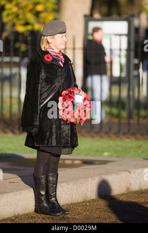 Una donna sola sorge nella parte anteriore della Guardia Memorial con una ghirlanda di papavero sul Giorno del Ricordo 11 novembre 2012] Londra Foto Stock