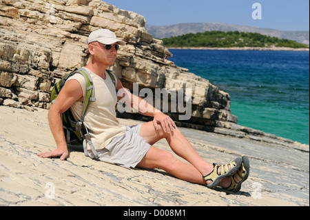 Outdoor uomo appoggiato sulla roccia dopo escursioni, Croazia Foto Stock