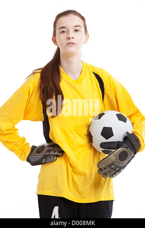 Ritratto di giovane donna soccer giocatore in possesso palla con mano su hip contro uno sfondo bianco Foto Stock