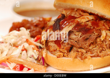 Grigliata di carne di maiale tirato in sandwich con coleslaw e fagioli al forno Foto Stock