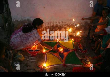 Ragazza indù schiarire le lampade di terracotta durante la cerimonia per festeggiare il Diwali Festival tenutosi Swami Narayan Temple a Karachi il Martedì, Novembre 13, 2012. La comunità Indù in tutto il Pakistan è celebrare la loro festa religiosa, Diwali. Membri della comunità indù illuminato di lampade a olio al di fuori dei templi, le loro case e i loro negozi dopo che pooja cerimonie furono tenuti presso i templi. Il trionfo del bene sul male, colorato rangolis (pattern fatta da colori) e petardi sono i punti culminanti del festival indù. Foto Stock