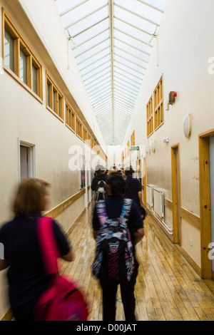 Schoolpupils camminando nel corridoio tra le lezioni presso un secondario completo scuola, Wales UK Foto Stock