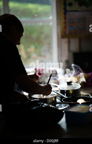 Le ragazze la cottura in un interno di cucina scienza tecnologia alimentare lezione a un secondario completo scuola, Wales UK Foto Stock