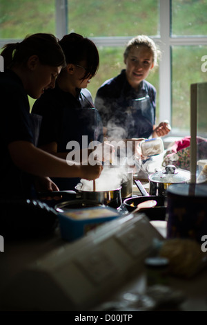 Le ragazze la cottura in un interno di cucina scienza tecnologia alimentare lezione a un secondario completo scuola, Wales UK Foto Stock