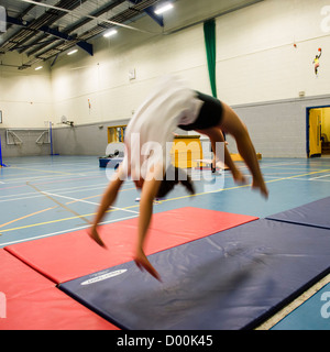 Una ragazza in un educazione fisica classe nella palestra presso un secondario completo scuola, Wales UK Foto Stock