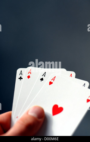 Mano e quattro assi che mostra il concetto di poker con copyspace Foto Stock