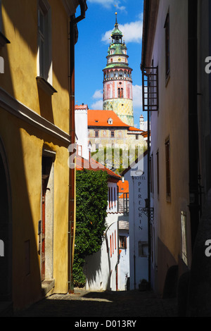 Vicolo a Cesky Krumlov con il castello di torre rotonda in background. Repubblica ceca Foto Stock