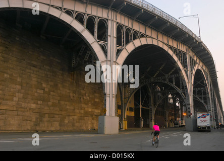 Ciclista scorre al di sotto del viadotto sul fiume sul lato ovest pista ciclabile. Foto Stock