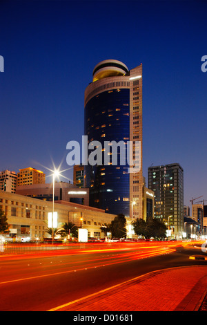 Il sangue-red road contrasta splendidamente con il blu del cielo in questo streetscabe di Abu Dhabi Foto Stock