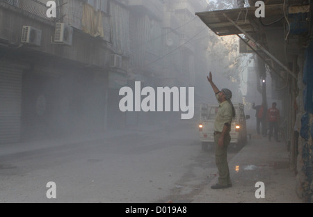 1 novembre 2012 - Aleppo, Siria: un uomo reagisce a tre turni di malte di essere licenziato in un edificio e strada. Foto Stock