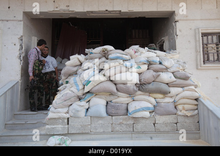 Aleppo, Siria: Libero esercito siriano membri a piedi attraverso il Salhin stazione di polizia durante l'Eid Al Ada vacanza. La stazione susta Foto Stock