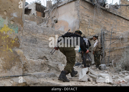 Ottobre 25, 2012 - Aleppo, Siria: Libero esercito siriano elementi girano in passato un cecchini vista in Safa. Foto Stock