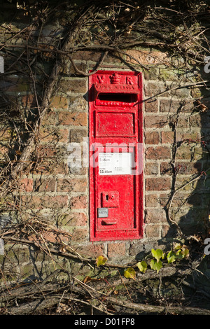 Un vecchio rosso postbox che può essere trovato in un muro di mattoni in Granchester, Cambridgeshire. Foto Stock